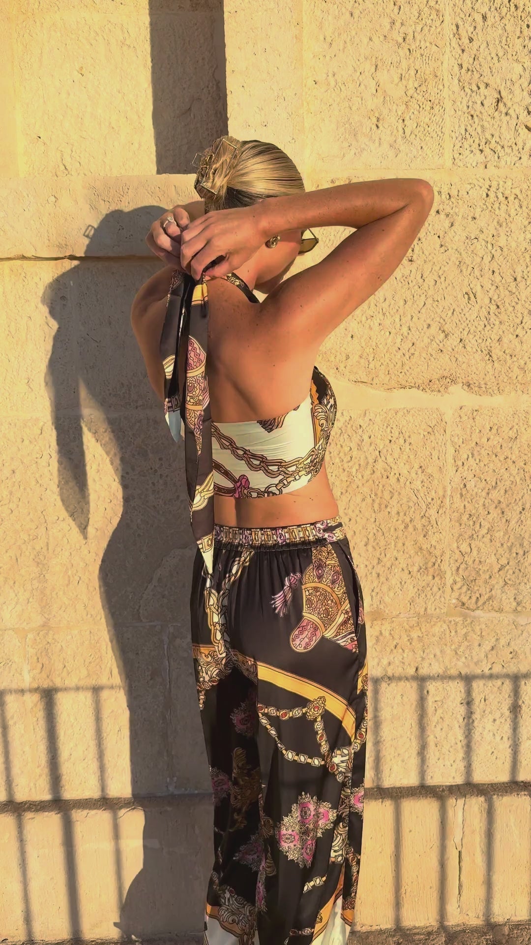 Monaco women's satin set video, back view of the halter top and trousers against a stone wall, We Hustle