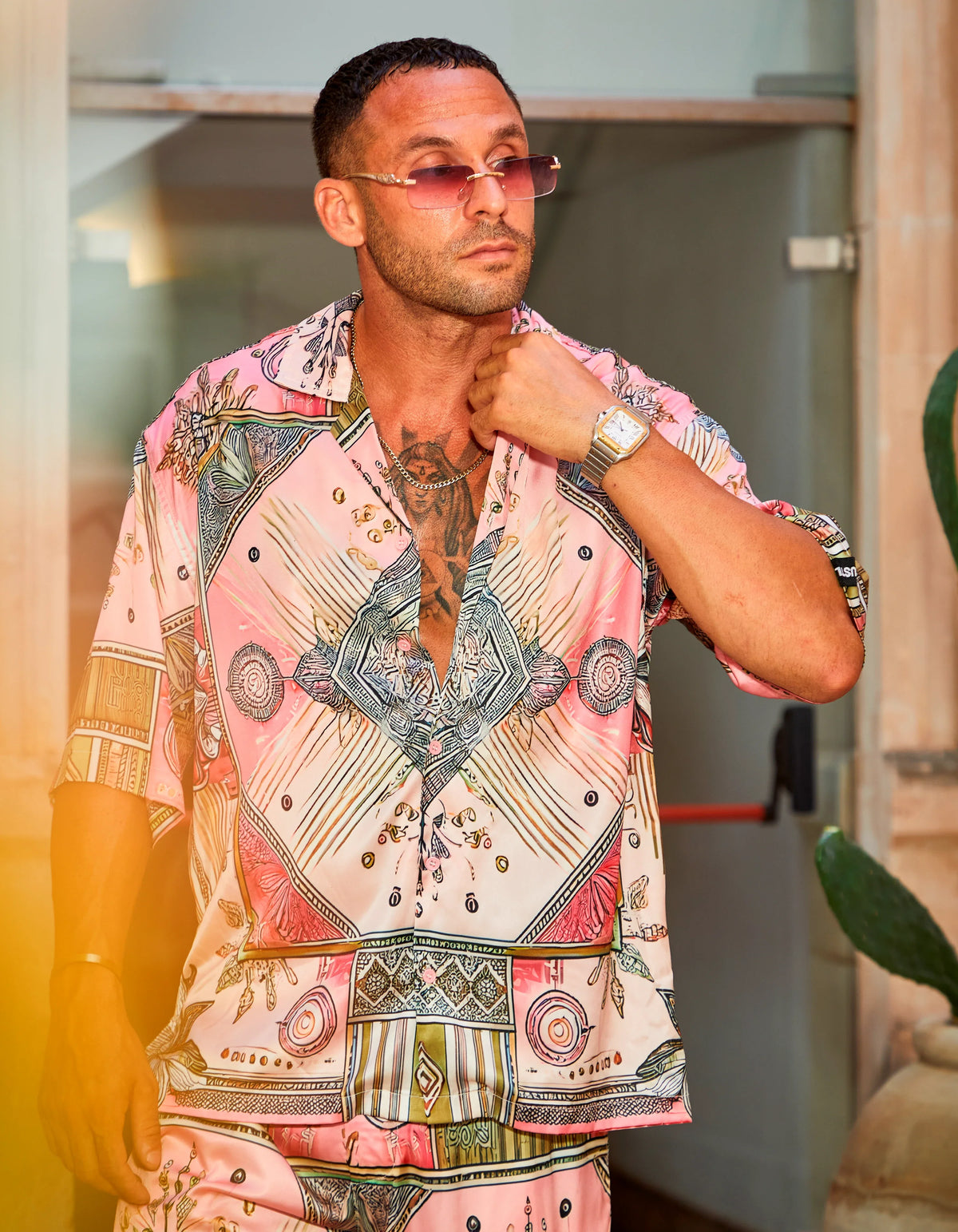 Scar City men's satin shirt worn as the co-ord set in a stone courtyard, We Hustle